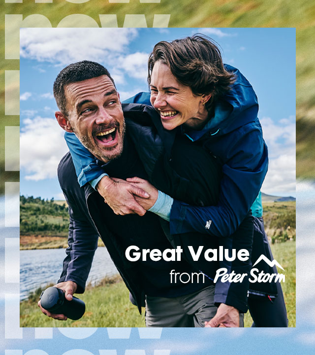 A woman walking in the mountains wearing a down jacket, fleece and a rucksack.