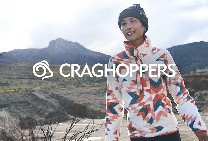 Woman walking past mountains wearing a Craghoppers fleece
