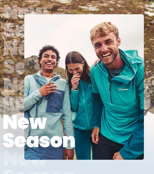 Group of friends wearing walking hear standing on the side of a mountain