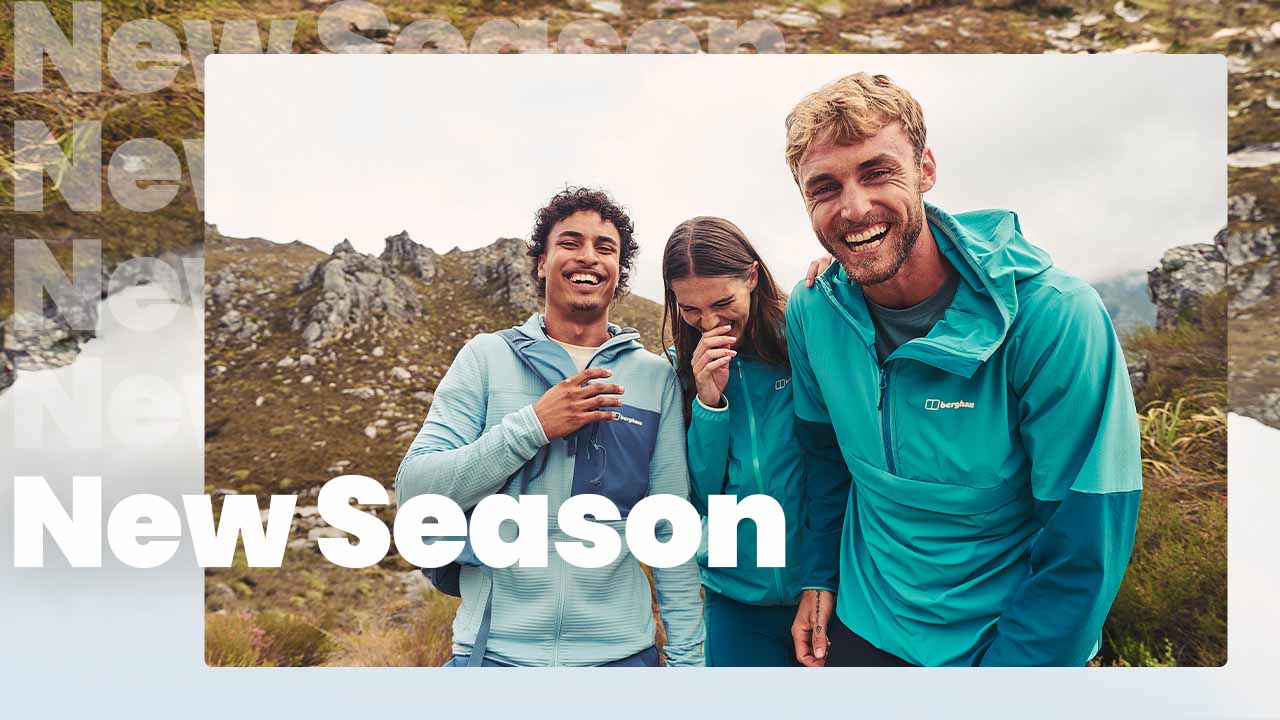 Group of friends wearing walking hear standing on the side of a mountain