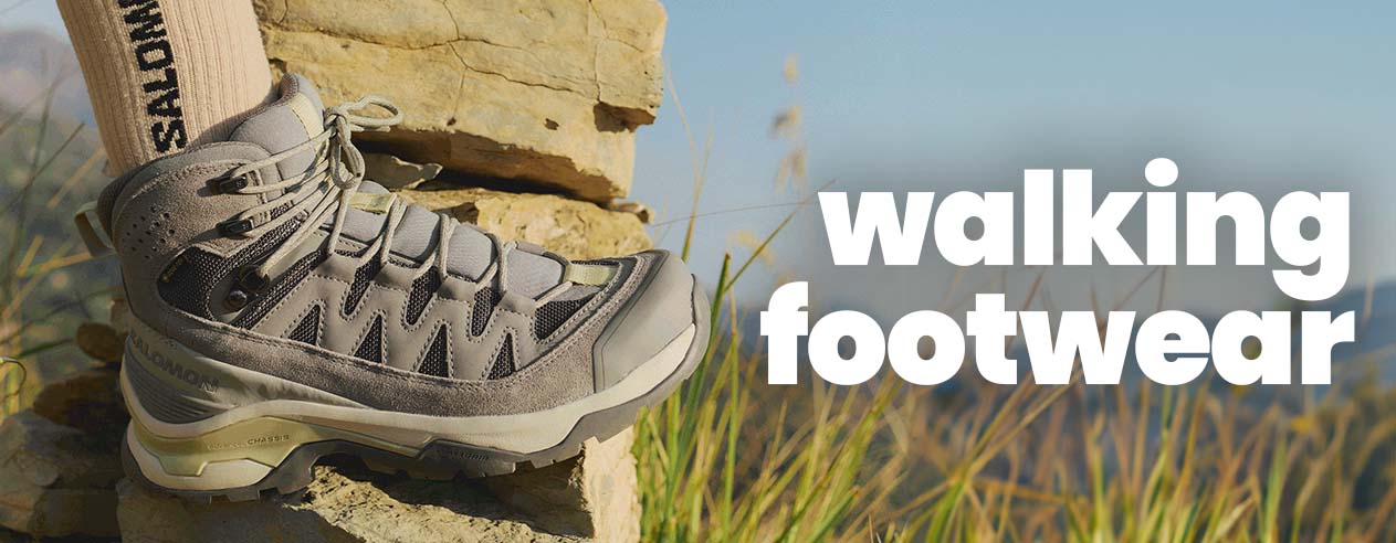 Hiker wearing a walking boot standing on a rock