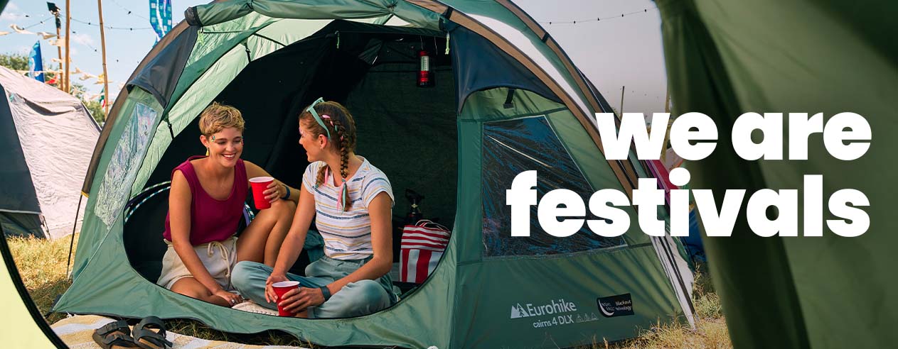 Women sitting inside a green tent at a festival