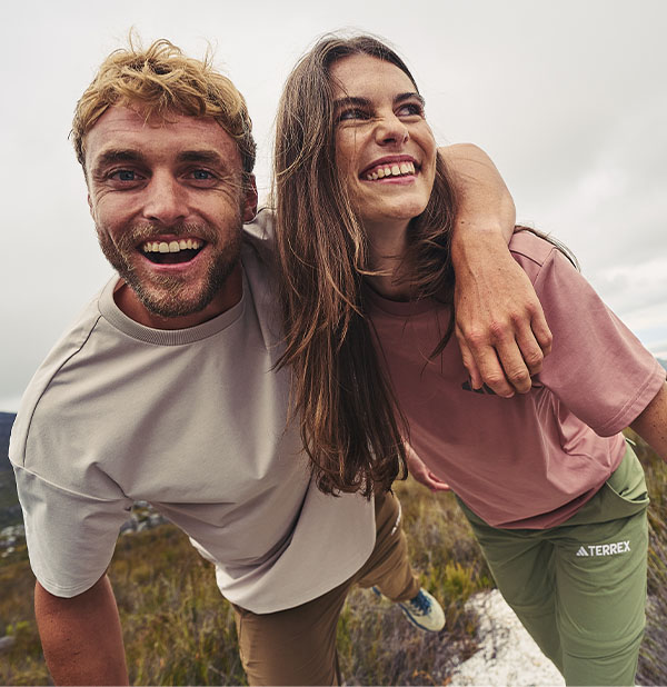 Man and woman wearing t-shirts standing on a mountain