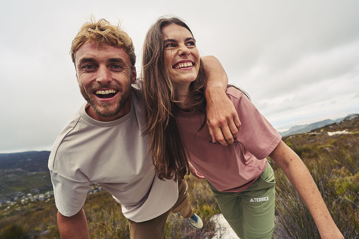 Man and woman wearing t-shirts standing on a mountain