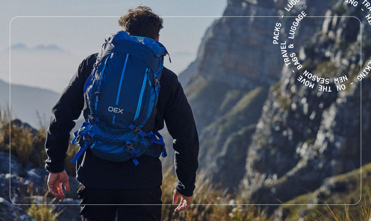 A person hiking in the mountains wearing a blue rucksack
