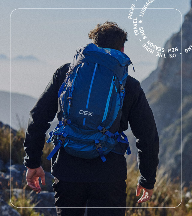 A person hiking in the mountains wearing a blue rucksack