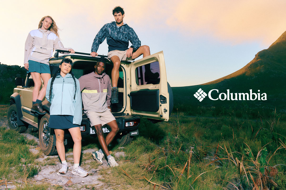 A group of people sitting out of the back of a truck in the mountains