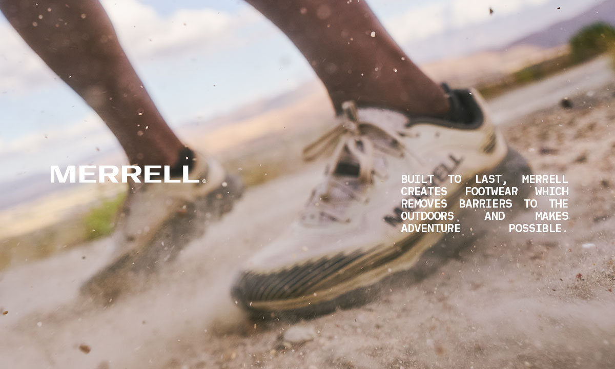 Closeup image of a Merrell shoe on a dusty trail.