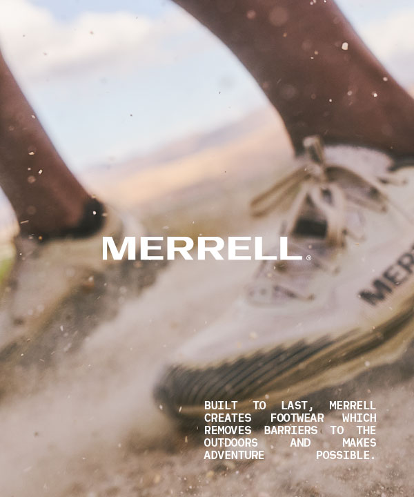 Closeup image of a Merrell shoe on a dusty trail.