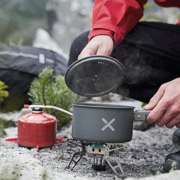 A person boiling some water on a camping stove.