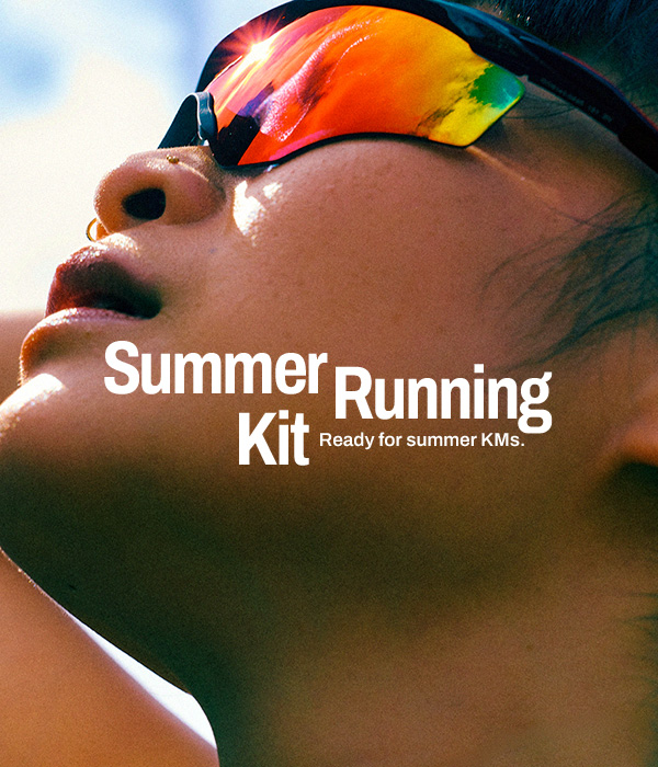 Close-up of a person wearing reflective wraparound sunglasses, head tilted back in bright sunlight, with a small arm tattoo visible; bold overlay text reads “Summer Running Kit” with the subtitle “Ready for summer KMs.”