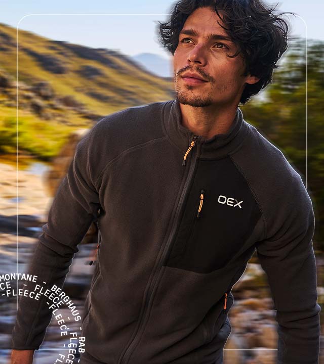 Man wearing a fleece walking through mountains
