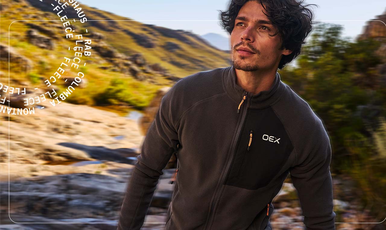 Man wearing a fleece walking through mountains