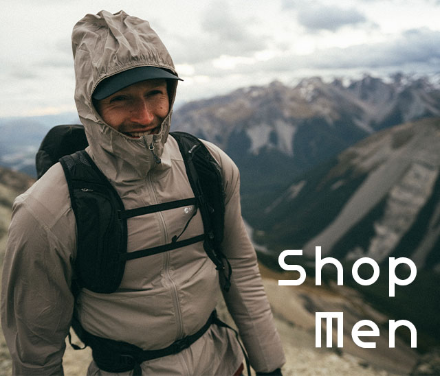 Man wearing a Montane jacket and backpack hiking up a mouitain