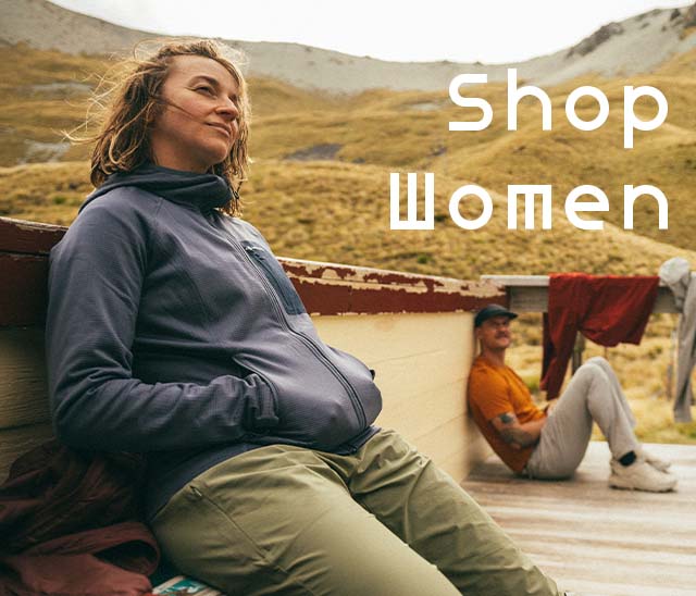Woman leaning on a roof wearing a Montane fleece with mountains in the background