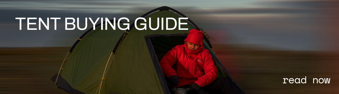 Man wearing a red jacket coming out of a tent 