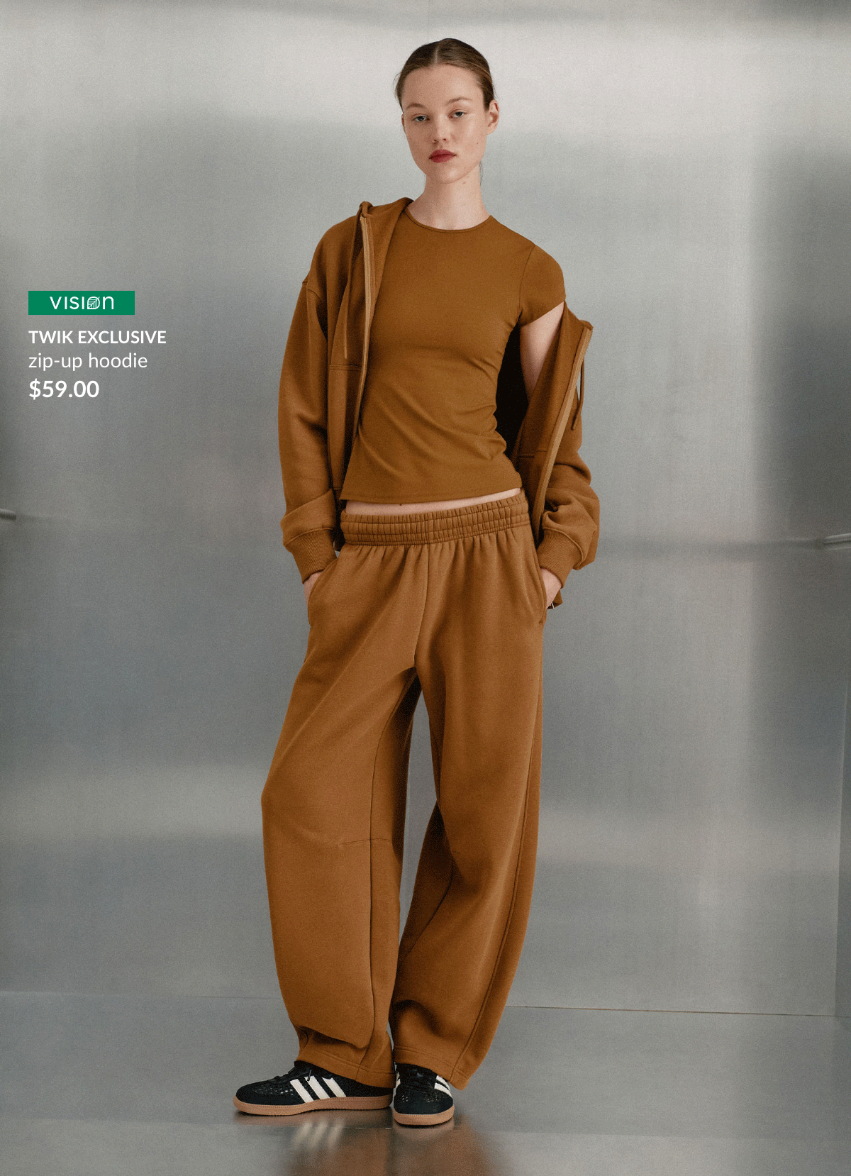 Young woman wearing a Twik exclusive coffee-brown zip-up hoodie, $59