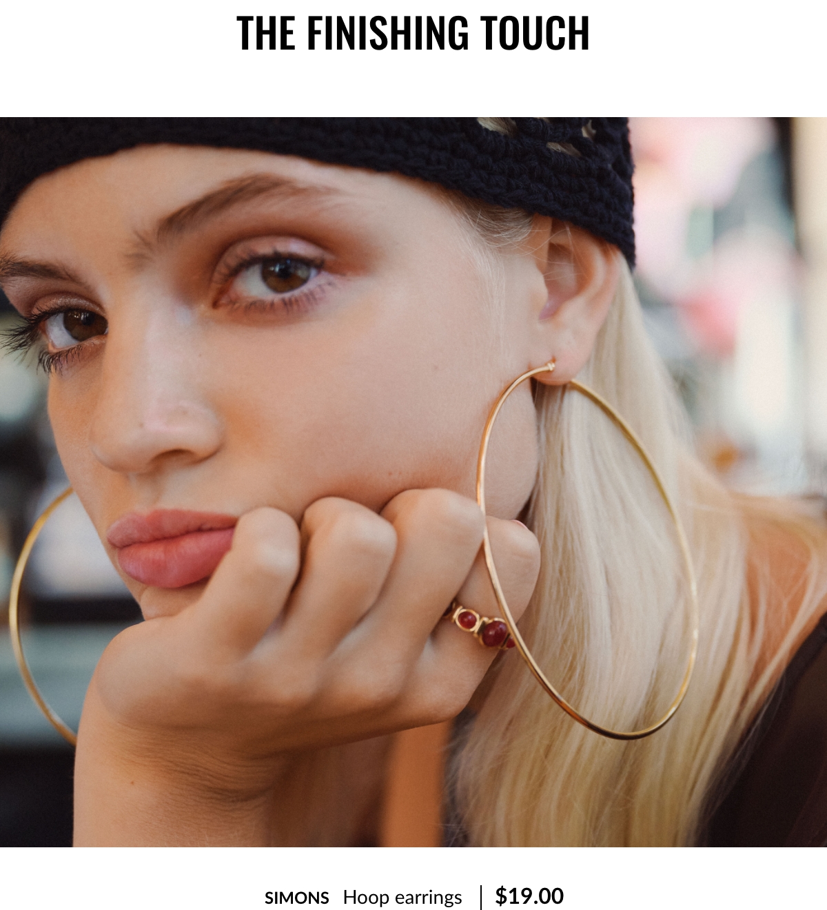 The finishing touch. Young woman wearing very large gold hoop earrings priced at $19