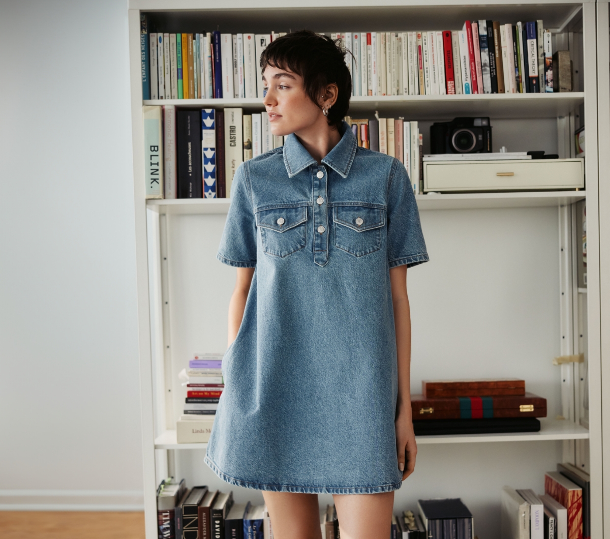 A young woman wears a denim dress