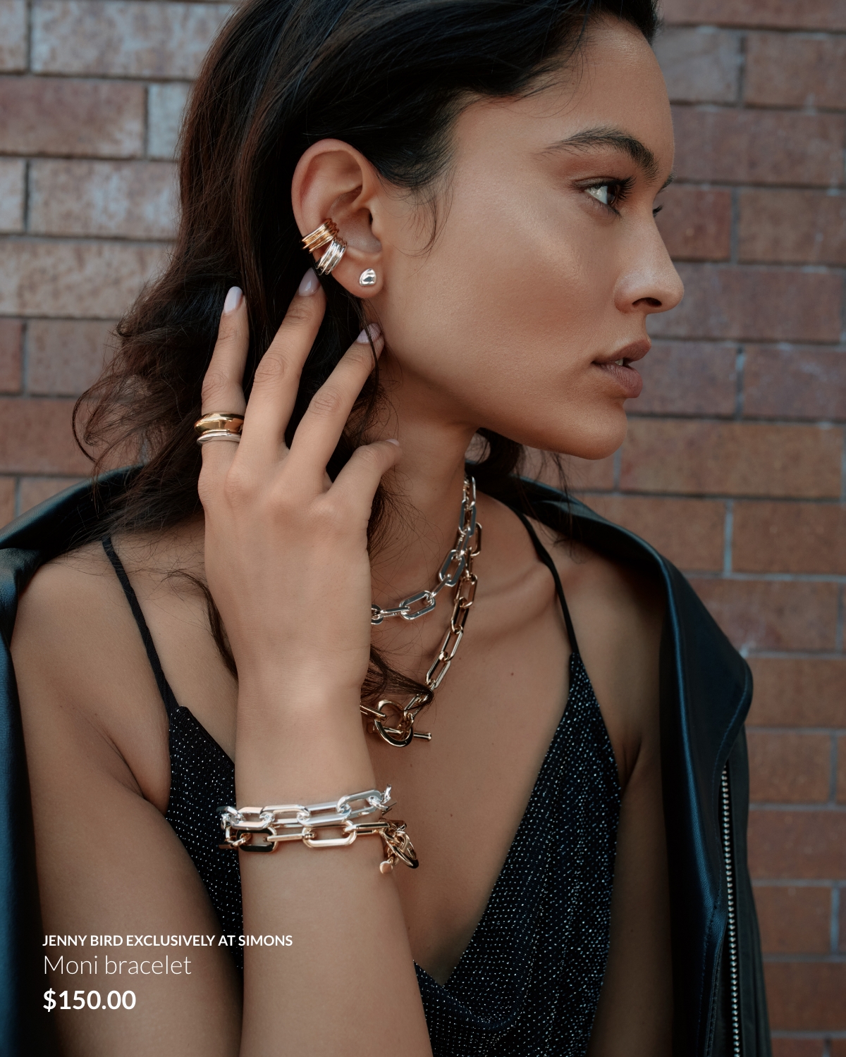 Woman wearing a shiny black tank top and mixed metal jewellery like the Moni bracelet from Jenny Bird at 150$