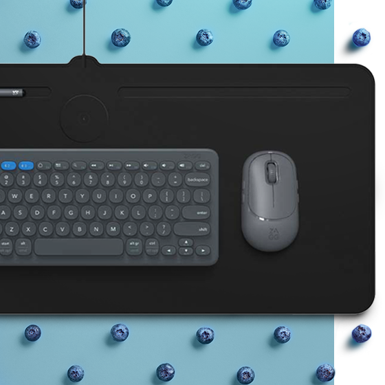 Wireless Charging Desk Mat on a blue background surrounded by blueberries