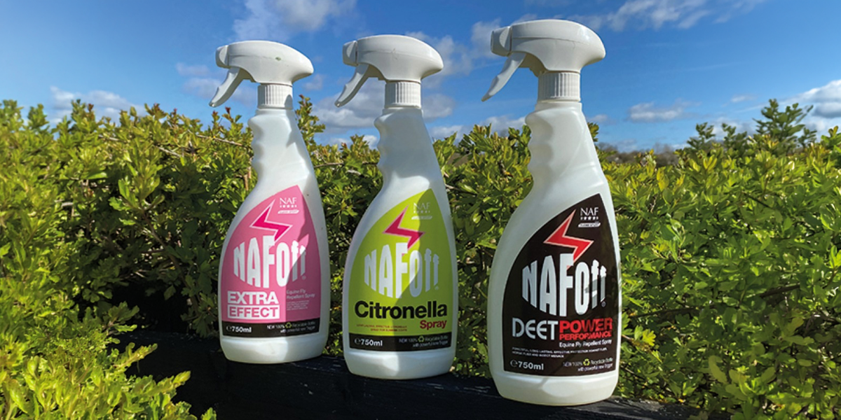 Three bottles of NafOff Spray against a backdrop of greenery and clear blue skies.