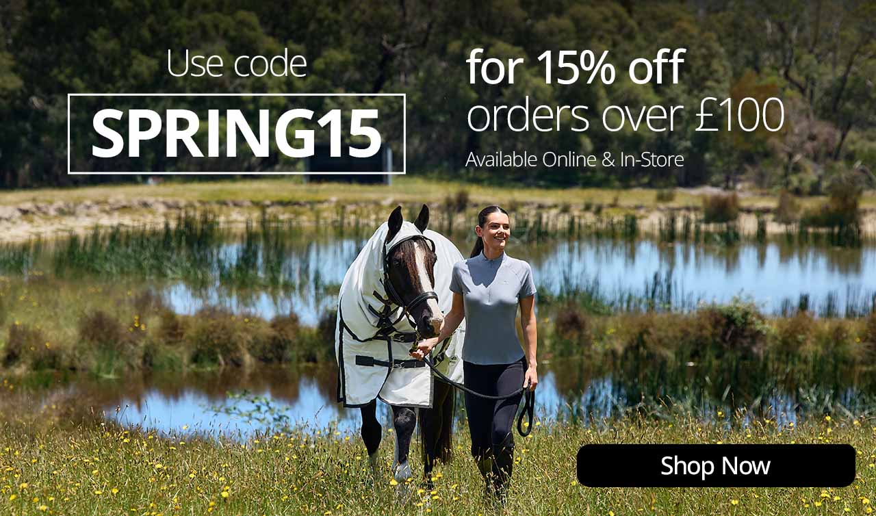 Promotional banner showing a person leading a horse wearing a white fly rug beside a lake, with text offering 15% off using code ‘SPRING15’ on orders over £100 and a ‘Shop Now’ button.