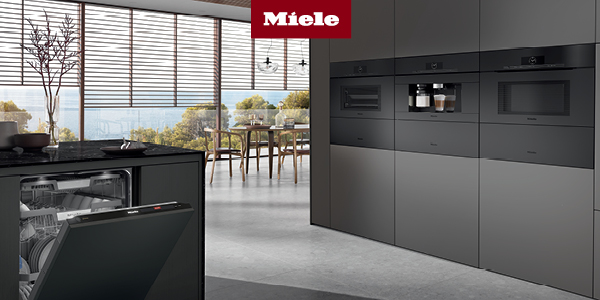 A kitchen with black cabinetry featuring a Miele dishwasher, ovens, and a built-in coffee machine 