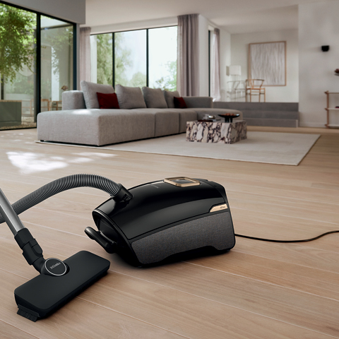 Guard vacuum cleaner on hardwood floor in living room 