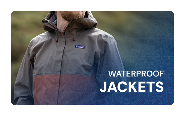 WATERPROOF JACKETS. A man stands in the rain wearing a Patagonia Men's Torrentshell 3L Rain Jacket in Brown. 
