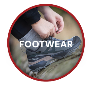 FOOTWEAR. A woman ties the laces of a Salomon Women's X Ultra 360 GORE-TEX Hiking Shoe in Blue.