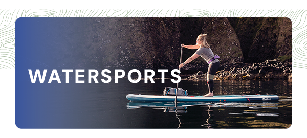 WATERSPORTS. A woman paddleboards on a loch in the sunshine. 