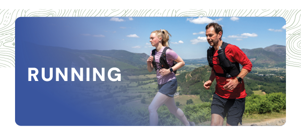 RUNNING. A man and a woman run along a trail under a blue sky. The woman wears a pink trail running tee, black running shorts and pink tights. The man wears a red long-sleeved t-shirt and black shorts. Both wear Inov-8 Racepac 4 Running Vest