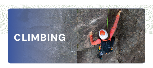 CLIMBING. A woman climbs a rock face, wearing a white and red helmet, pink climbing jacket and a black pack. 
