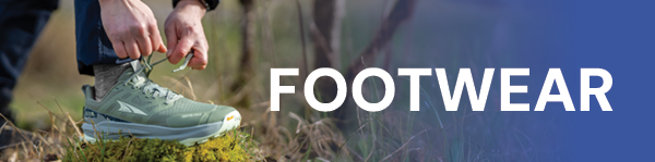 FOOTWEAR. A woman ties the laces of an Altra Women's Lone Peak 9+ GORE-TEX Shoe in Green.