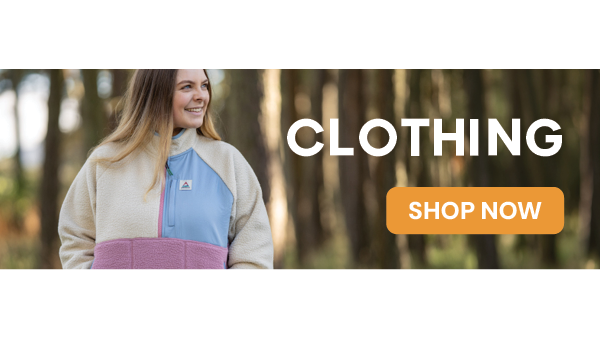 CLOTHING: SHOP NOW. A smiling woman walks through a forest wearing Passenger Women's Home 1/2 Zip Sherpa Fleece in Cream. 