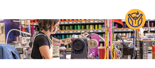 A woman sits at a sewing machine, repairing clothing. On the right, a blue graphic of a jacket with an arrow forming a circle behind it.