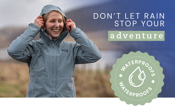 DON'T LET RAIN STOP YOUR ADVENTURE. A woman pulls up the hood of a Patagonia Women's Torrentshell 3L Rain Jacket in Light Blue. 