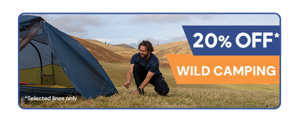 20% OFF WILD CAMPING* *Selected Lines Only. A man in a field pitches an OEX Phoxx I Ultralite 1-Person Tent.