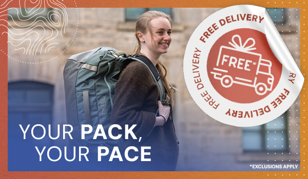 YOUR PACK, YOUR PACE. A woman walks through a street wearing an Osprey Transporter Duffel 65L. 
