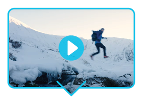 Fast and Light Scottish Mountaineering: Video still of a man jumping across a gap on a snowy mountain, wearing Mountain Equipment climbing gear. A blue play button sits in the centre of the image.
