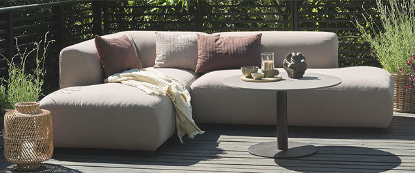 Időjárásálló kerti kanapé bézs színben egy teraszon