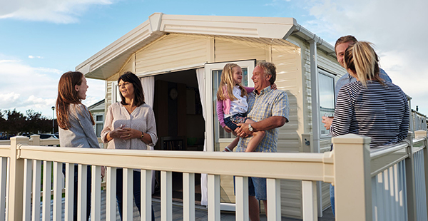 Family and friends enjoying a meal outside a caravan