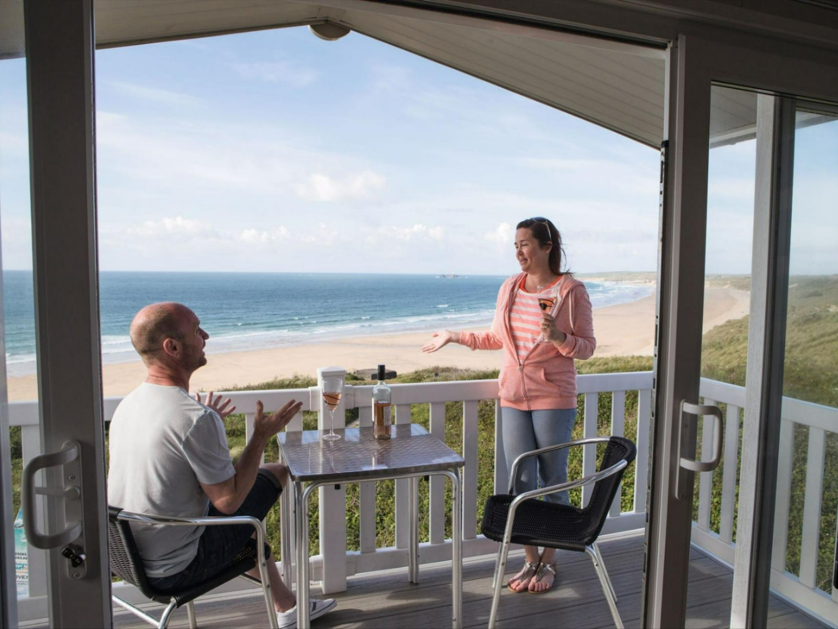 Owners looking out on the deck of their holiday home