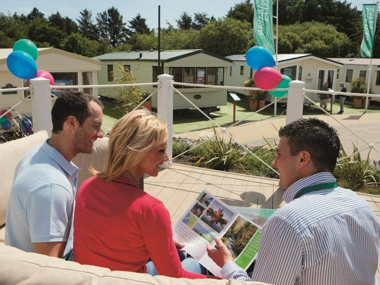 Couple with a Haven team member on a holiday park