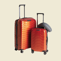Twee harde koffers in oranje en grijze kleur met uitschuifbare handgrepen en vier wielen.
