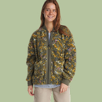Dame in een fleece vest met all-over natuurprint in groentinten en ritssluiting.