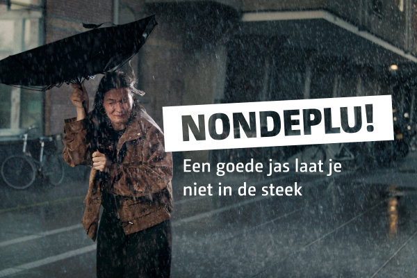 Afbeelding van een vrouw in de regen met een kapot gewaaide paraplu. In de afbeelding staat Nondeplu! Een goede jas laat je niet in de steek