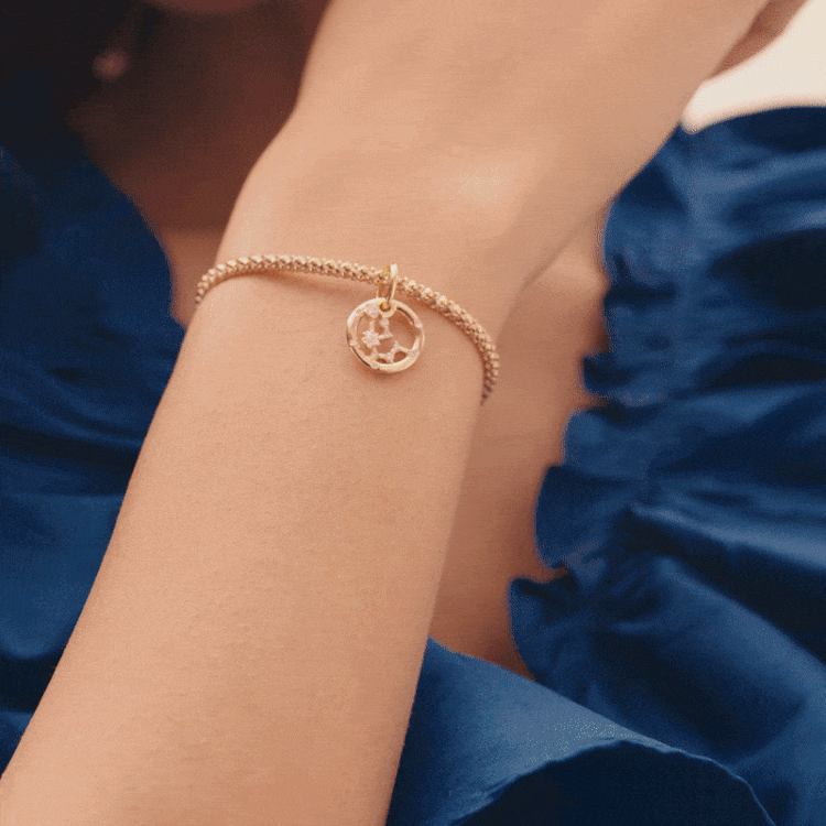 Model wearing Pandora Zodiacs with studded chain bracelet