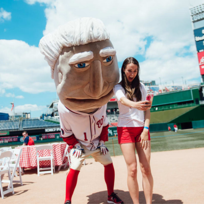 A fan poses with one of the Racing Presidents at National Park in Washington, DC.